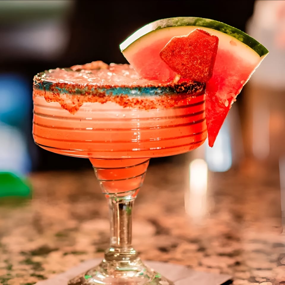 Watermelon margarita with a chili-lime rim and watermelon slice garnish at La Costa Mexican cantina.