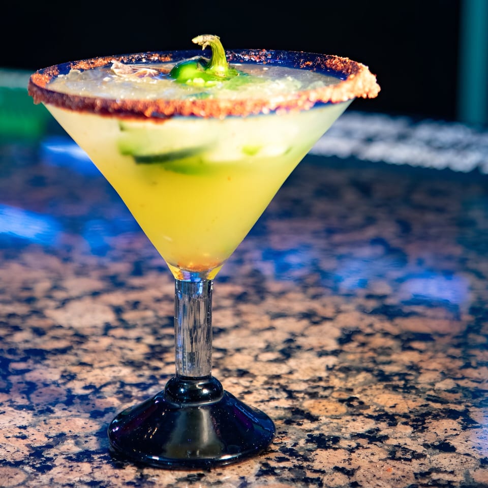 Spicy La Costa Mexican cantina margarita with a chili-salted rim and a green pepper garnish.